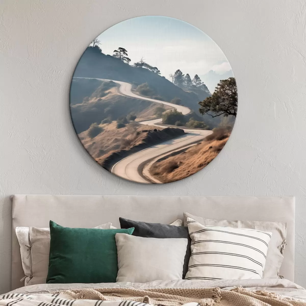 Tableaux rondes Une route sinueuse à travers un paysage vallonné recouvert d'herbe sèche, sous un ciel clair, avec des montagnes au loin r46289